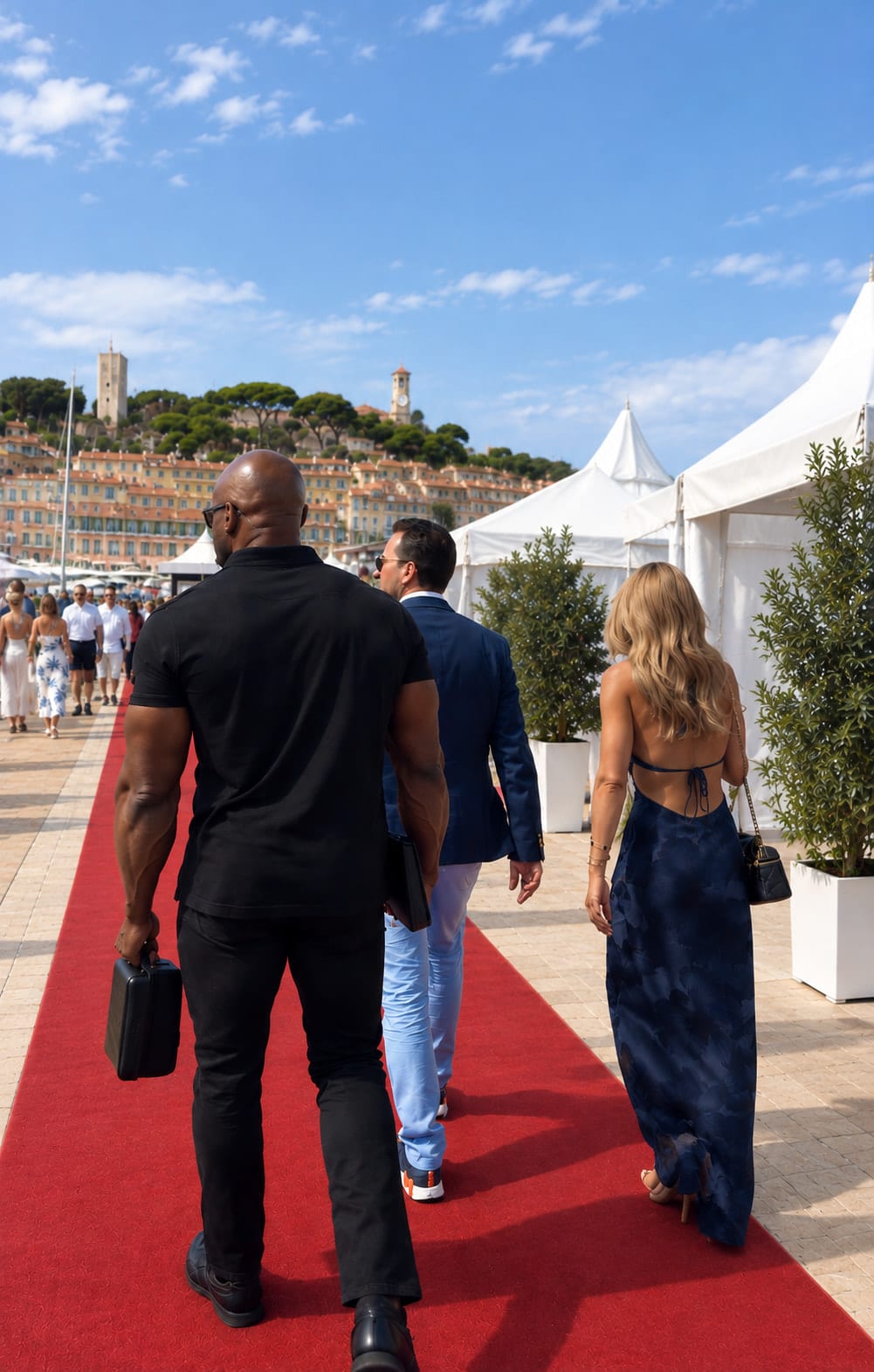 Agent de protection rapprochée en polo noir, de dos, sur le tapis rouge d'un événement au bord du port